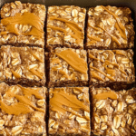 A pan of freshly baked High-Protein Peanut Butter–Banana Oatmeal Bars cooling on a wire rack.