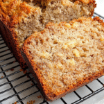 A golden loaf of Cottage Cheese Banana bread on a cooling rack.