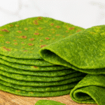 A vibrant green spinach oat bread stack on a wooden board.