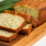 A sliced loaf of the best Keto Zucchini Bread with Almond Flour on a wooden board.