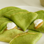 A stack of pancakes from a spinach oat pancakes protein recipe, topped with yogurt and berries.