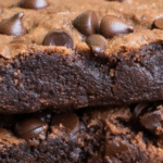 Close-up of thick fudgy protein brownies packed with chocolate chips and a rich, moist texture